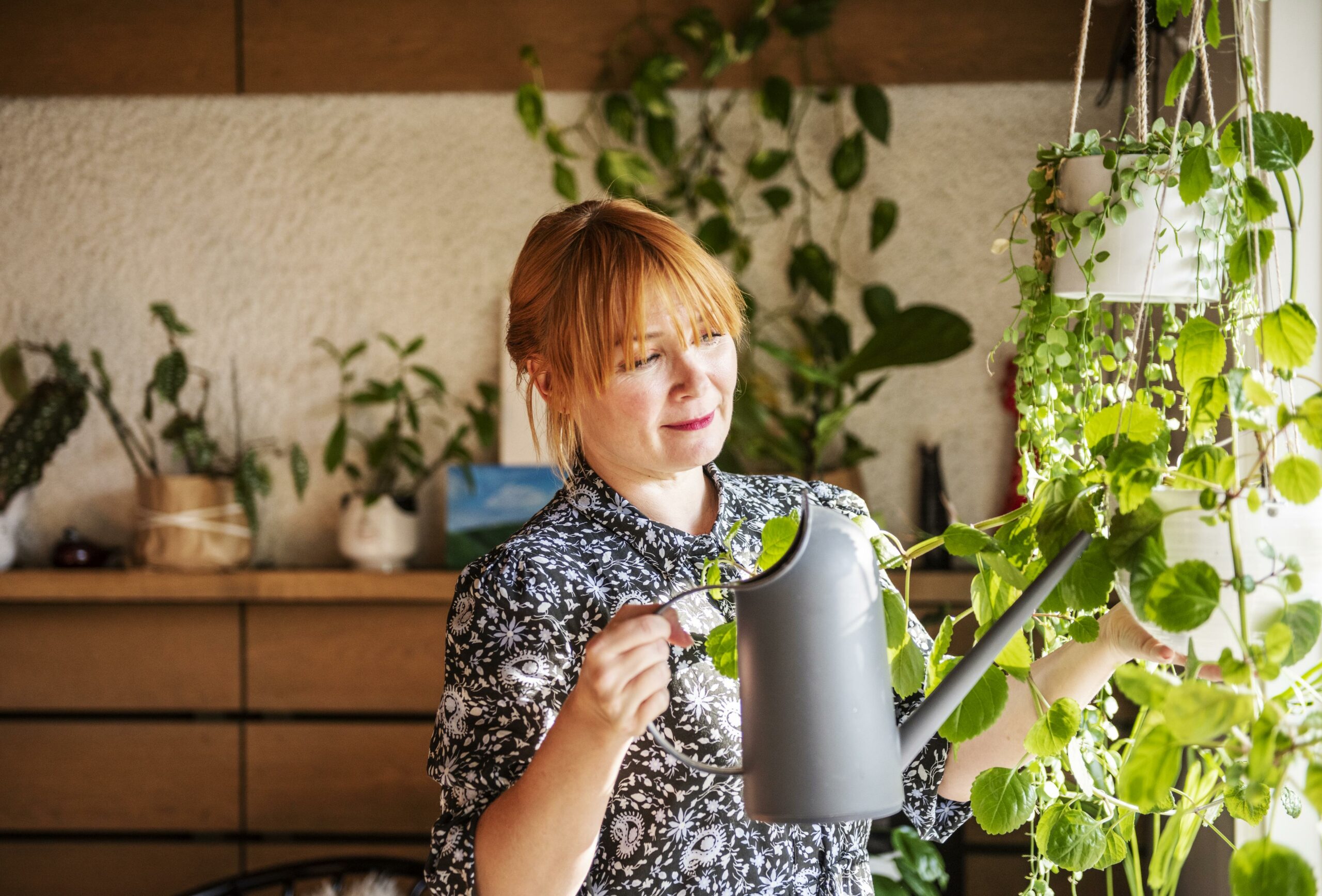 Muusikko Irina kastelee kukkia kotonaan. 