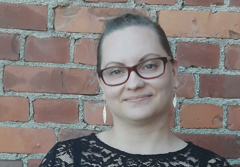 Kesätyöntekijä katsoo kameraan.
