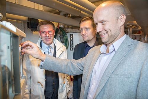 Miehet tutkimassa lämpöpumppuratkaisua.